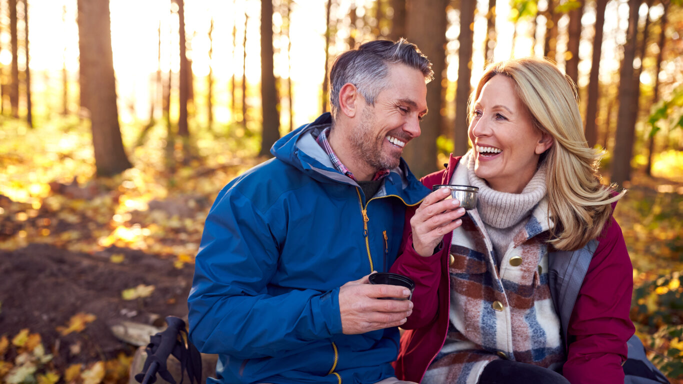 Mature Retired Couple Stop For Rest And Hot Drink On Walk Through Fall Or Winter Countryside