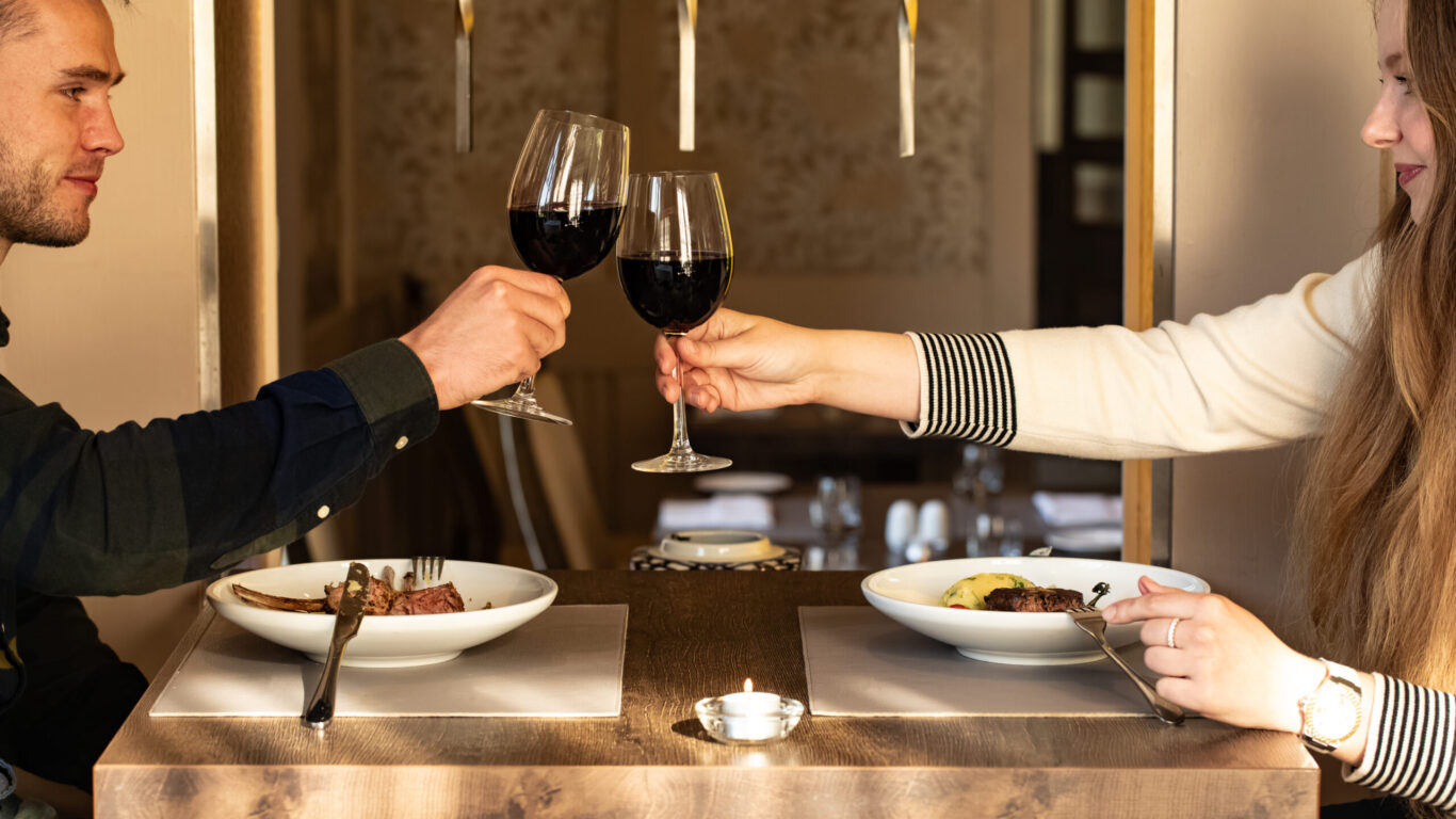 dining danú couple cheers wine